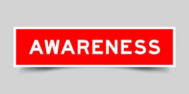 Red color square shape sticker label with word awareness on gray background