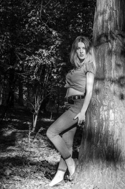 Kot pantolon ve ceket ağaçlar ve bitki örtüsü arasında ormanda poz uzun sarı saçlı genç güzel seksi kız sarışın model