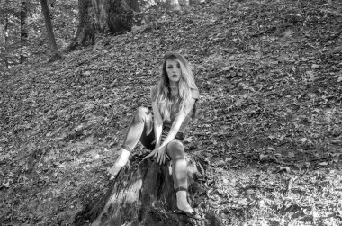 Kot pantolon ve ceket ağaçlar ve bitki örtüsü arasında ormanda poz uzun sarı saçlı genç güzel seksi kız sarışın model