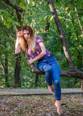 Kot pantolon ve ceket ağaçlar ve bitki örtüsü arasında ormanda poz uzun sarı saçlı genç güzel seksi kız sarışın model