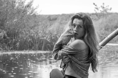 Genç güzel kadın modeli uzun sarı saçlı oturan farklı duygular kahkaha, üzüntü, keder, dalgınlık Nehri ve su almak için ormanın kıyısında ahşap bir köprü ile