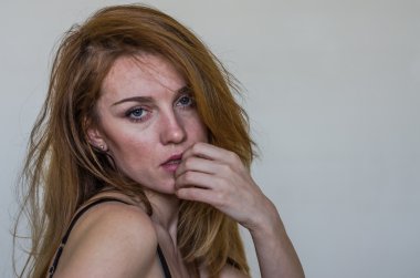 Uzun saçlı güzel seksi iç çamaşırı çarşaf üzerinde erotik poz ve ışık ışık arka plan üzerinde oturan genç büyüleyici kadın