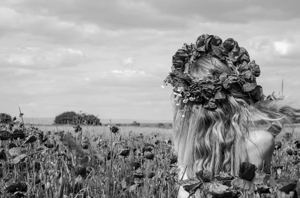 Giovane bella ragazza felice con i capelli lunghi in un abito bianco nel campo di papavero con una corona sulla testa — Foto Stock