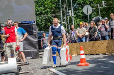 Lviv, Ukrayna - Haziran 2016: Diktatör bir büyük şişirilmiş metal gövdeli ağır bavul taşır