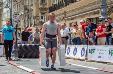 Lviv, Ukrayna - Haziran 2016: Diktatör bir büyük şişirilmiş metal gövdeli ağır bavul taşır
