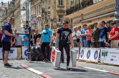 Lviv, Ukrayna - Haziran 2016: Diktatör bir büyük şişirilmiş metal gövdeli ağır bavul taşır