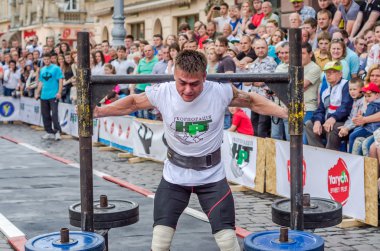 Lviv, Ukrayna - Haziran 2016: Atlet vücut geliştirmeci diktatör güçlü gövdeli bir şehir sokak çubuk ile pancakes ile büyük bir metal yapı vardır