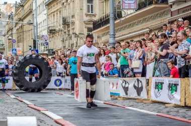 Lviv, Ukrayna - Haziran 2016: Diktatör bir büyük şişirilmiş metal gövdeli ağır bavul taşır