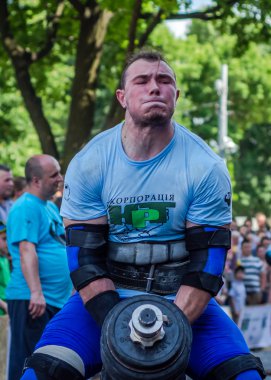 Lviv, Ukrayna - Haziran 2016: Güçlü atlet vücut geliştirmeci diktatör bir şehir sokak seyirci önünde ağır halter kaldırıyor