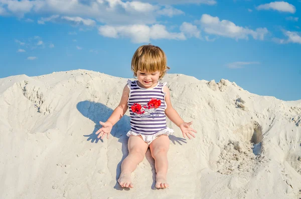 Mały uroczy dziewczyna baby, baby T-shirt, strój kąpielowy i roześmiany szczęśliwy kapelusz i gra w biały piasek na plaży, nad morzem, jasny, słoneczny dzień gorący w ośrodku podczas wakacji rodzice — Zdjęcie stockowe