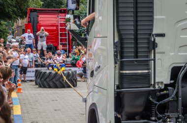 Lviv, Ukrayna - Temmuz 2016: güçlü atlet diktatör bir ortakla oturan bir ip kamyon çekerek büyük lastikler değil