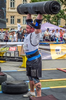 Lviv, Ukrayna - Temmuz 2016: güçlü atlet vücut geliştirmeci diktatör ağır beden ile pompalanır güneşli bir günde bir paket sokakta coşkulu seyirci önünde çıtayı yükseltiyor