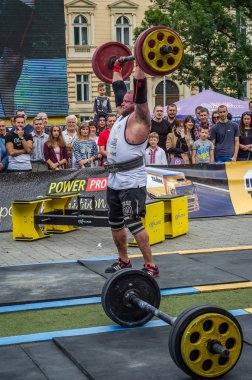 Lviv, Ukrayna - Temmuz 2016: güçlü atlet vücut geliştirmeci diktatör ağır beden ile pompalanır güneşli bir günde bir paket sokakta coşkulu seyirci önünde çıtayı yükseltiyor