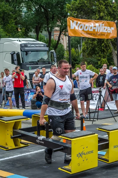 LVIV, UCRANIA - JULIO 2016: Fuerte atleta culturista fuerte lleva competiciones de diseño de heavy metal World Strongest Team ante audiencias entusiastas — Foto de Stock