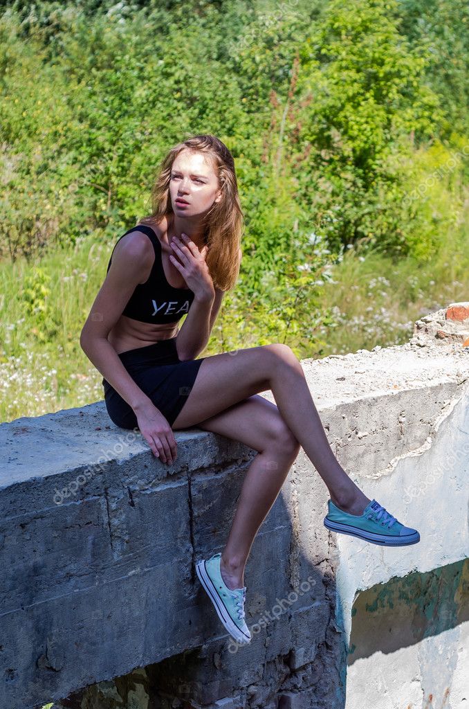 Young Charming Sexy Teen Girl With Long Hair In A Short Mini Skirt And Tank Top