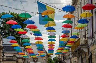 Çok renkli şemsiyeler kasabada asılı