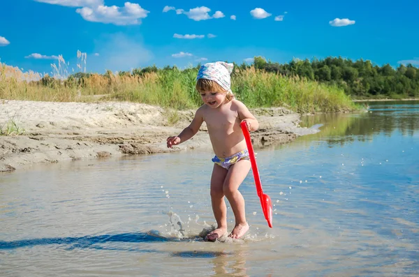 Mały uroczy dziewczyna dziecko bawiące się na jezioro, pływanie w wodzie podczas wakacji w ośrodku na piaszczystej plaży — Zdjęcie stockowe