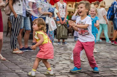 Lviv, Ukrayna - Ağustos 2016:, neşeli ve yayılan olumlu duygular, sabun köpüğü şehir, alıcı genç çocuklar oynarken mutlu çocuk