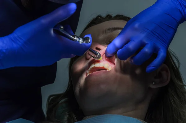 歯医者は歯科治療中に患者の歯茎に麻酔注射をします — ストック写真
