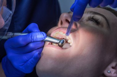 Doktor dişçi kadınlara diş tedavisi uygular.