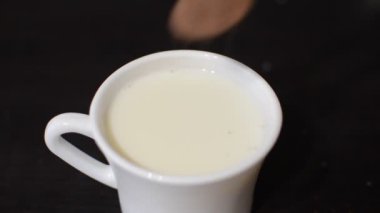 Kakao tozu sütle bardağa dökülür.