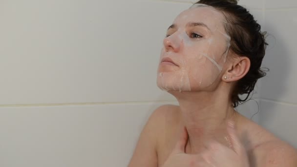 Junge Charmante Frau Setzt Bei Wellness Behandlungen Gesichtsmaske Aus Stoff — Stockvideo