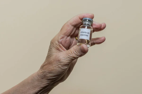 Covid-19 vaccine in the hand of an elderly woman