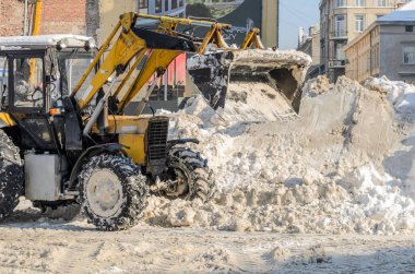 LVIV, UKRAINE - Şubat 2021: Kar temizleme traktörü yolu kardan temizliyor