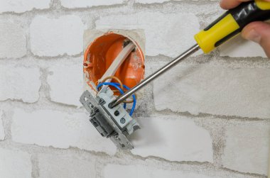 Bir dairede elektrik şalterini tamir eden bir elektrikçi.