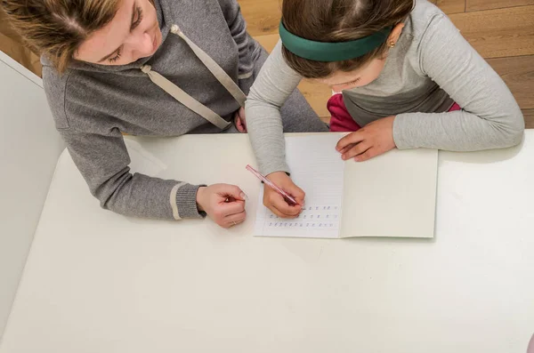 Mom and daughter do school homework, learn to write letters