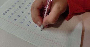 Küçük kız ödev yapıyor, mektup yazmayı öğreniyor.