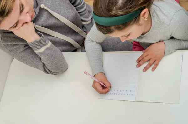 Mom and daughter do school homework, learn to write letters