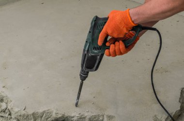 İnşaatçı delgiyi söker ve inşaat alanındaki beton zemini kırar.