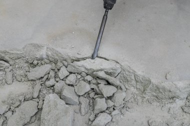 İnşaatçı delgiyi söker ve inşaat alanındaki beton zemini kırar.