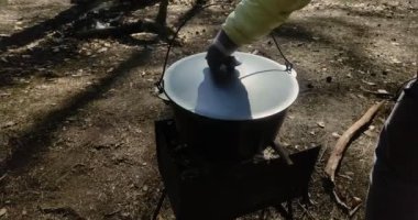 Balık çorbalı bir tencere piknikte açık ateşte ızgarada pişirilir.