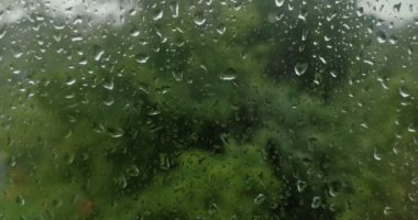 Şiddetli yağmurda su damlaları pencereden aşağı akıyor