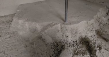İşçi beton zemini çekiçle deliyor.