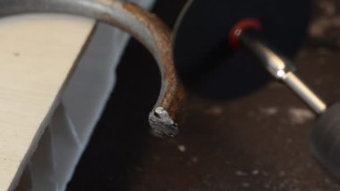 Usta oymacı metali öğütücü tekerlekle işliyor.