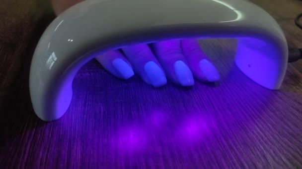 Flicka Lägger Sin Hand Ultraviolett Lampa För Att Torka Manikyr — Stockvideo