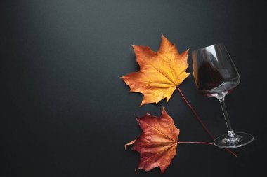 Kırmızı şarap kadehi ve üzüm yaprakları sonbahar kompozisyonu