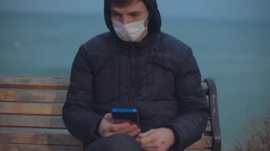Yakın plan. Adam telefona bakmış. Sonra kamera yüzünü nasıl kaldırdığını ve düşündüğünü gösteriyor.