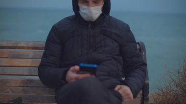 Yakın plan. Adam telefona bakmış. Sonra kamera yüzünü nasıl kaldırdığını ve düşündüğünü gösteriyor.