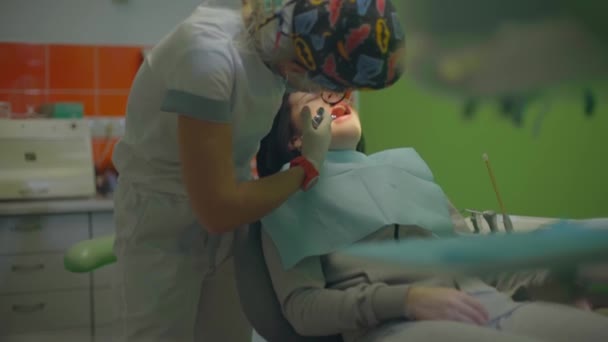 Jonge dame zit in een tandartsstoel vrouwelijke arts doen anesthesie — Stockvideo