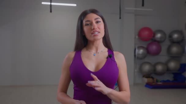 Бикини фитнес девушка говорит что-то в камеру — стоковое видео