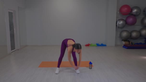 Menina atlética fazendo curvas para o chão nas laterais — Vídeo de Stock