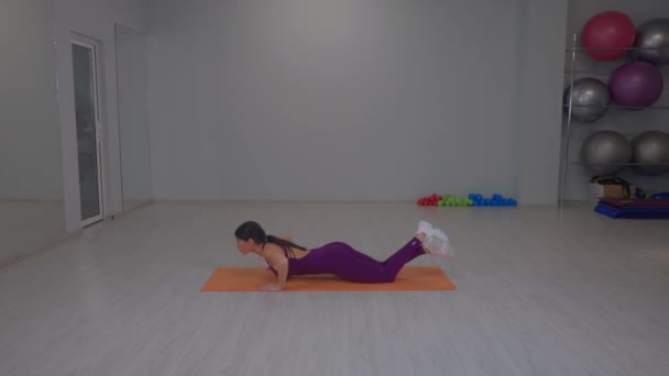 Athletic girl performs push-ups lying down — Wideo stockowe