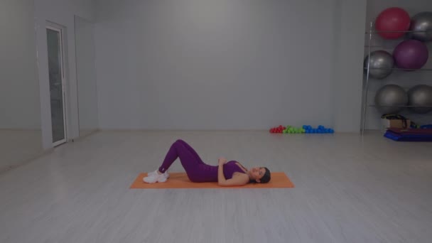 Ajuste mujer joven descansando en la estera del yoga — Vídeo de stock