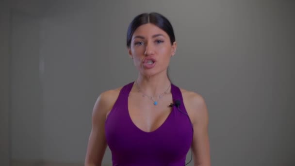 Bikini κορίτσι γυμναστικής λέει κάτι στην κάμερα — Αρχείο Βίντεο