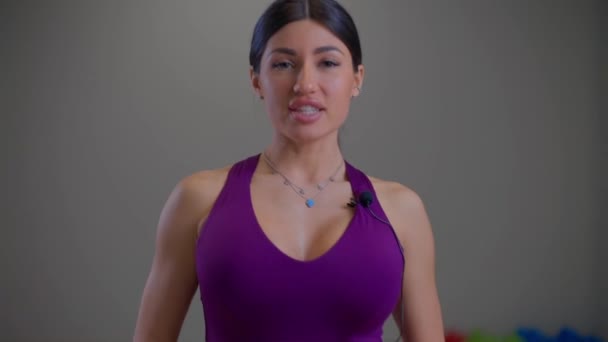 Бикини фитнес девушка говорит что-то в камеру — стоковое видео