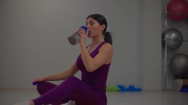 Schöne athletische Mädchen trinken Wasser — Stockvideo